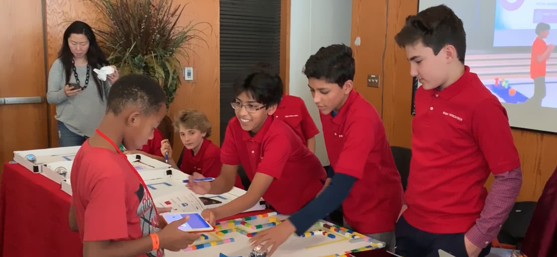 Slide Image - arjun handing student an ipad